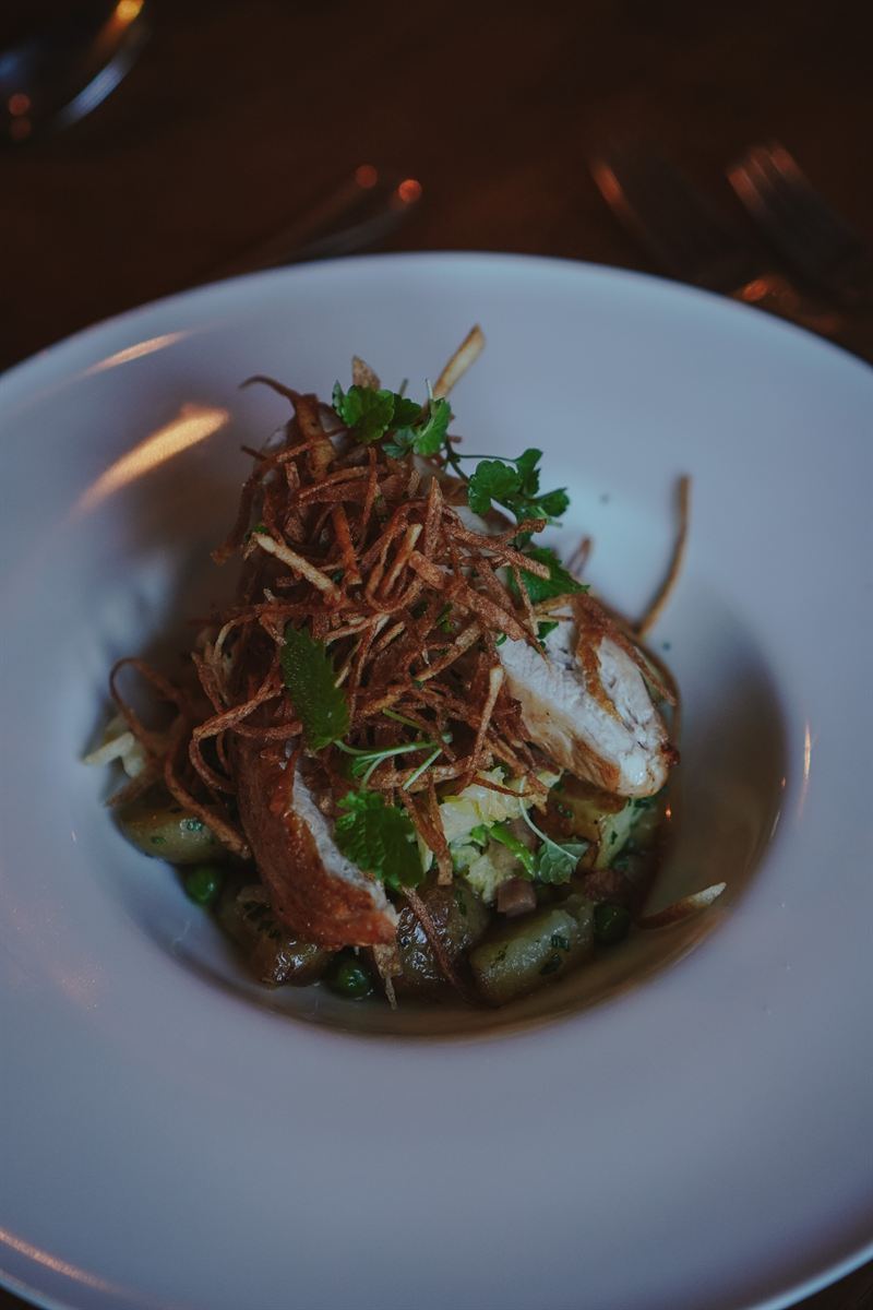 Chicken supreme with crispy potato straws and fresh herbs